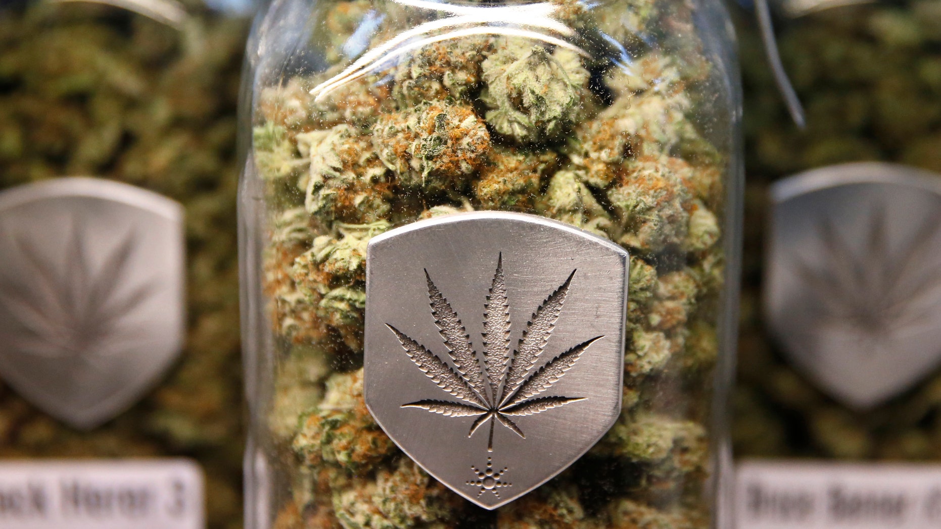FILE- In this Dec. 27, 2013 file photo, different strains of pot are displayed for sale at a marijuana dispensary in Denver. The state of Colorado released a report Monday, April 18, 2016 detailing changes in everything from pot arrests to tax collections to calls to Poison Control. The most striking statistic wasn't a change at all, but the fact that surveys indicate marijuana use by people under 18 didn't rise significantly in the years after the 2012 vote to legalize recreational pot sales. (AP Photo/Brennan Linsley, file)