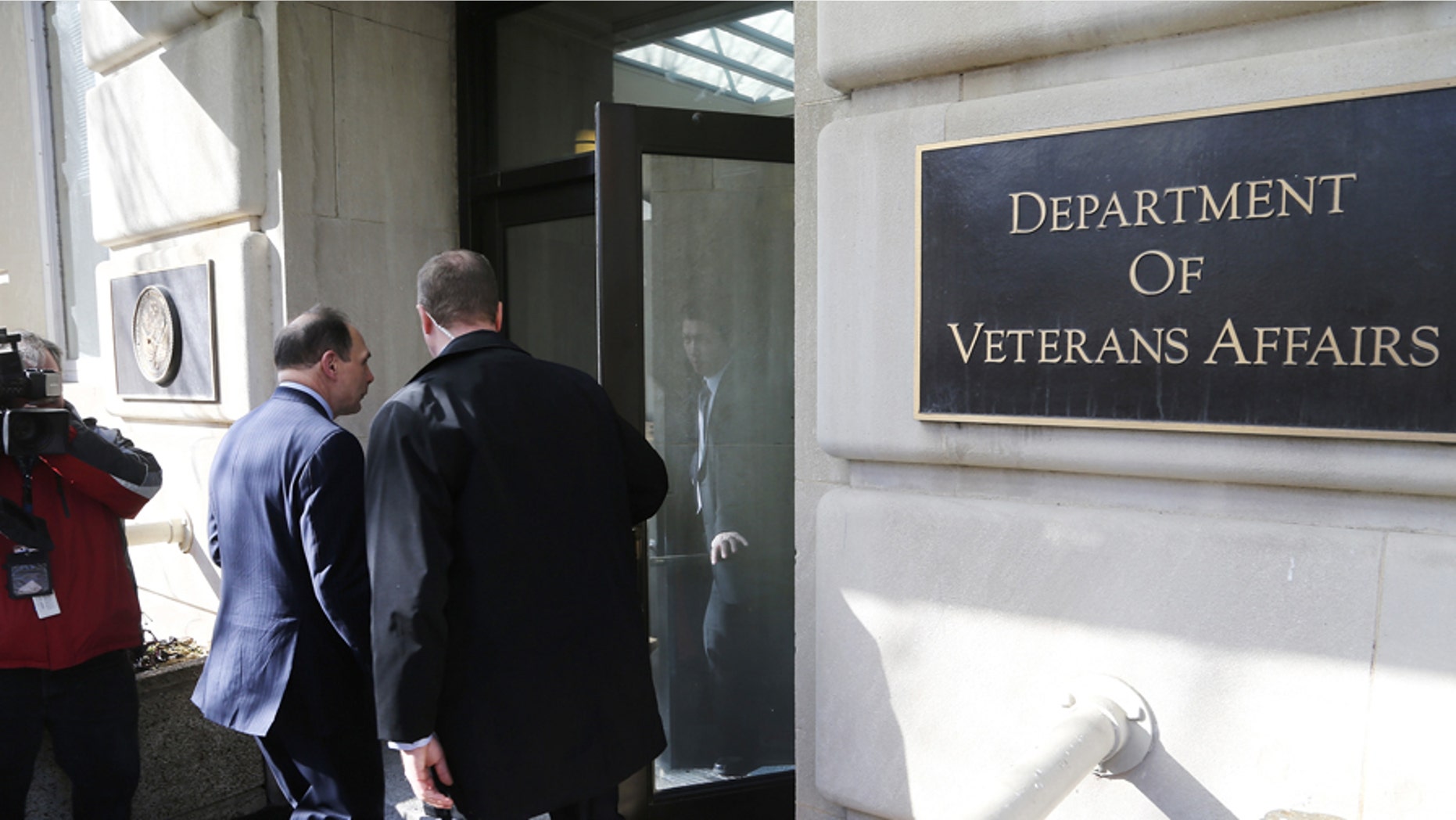 U.S. Department of Veterans Affairs Secretary Robert McDonald (L) departs into the building after delivering an apology, for recent misstatements about his military record, to reporters outside VA headquarters in Washington, February 24, 2015. REUTERS/Jonathan Ernst (UNITED STATES - Tags: POLITICS MILITARY) - GM1EB2P0CWL01