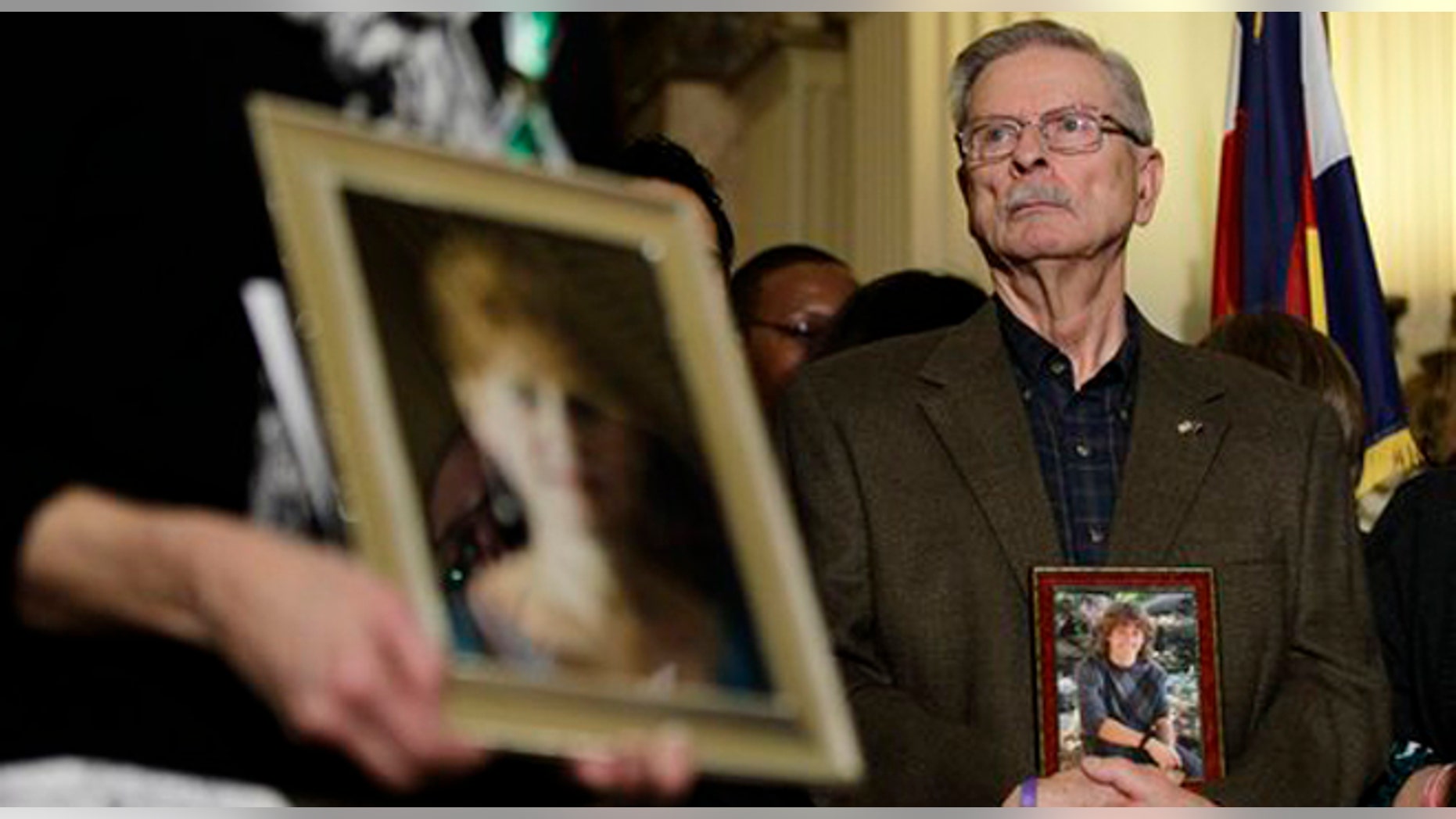 Bill Hoover carries a photo of his grandson AJ Boik, who was killed in the July, 2012 Aurora movie theatre massacre, during a news conference at which Colorado State legislators unveiled gun control measures, at the State Capitol, in Denver, Tuesday Feb. 5, 2013. Among the proposed measures is a new bill that would hold manufacturers, sellers, and owners of assault weapons liable and responsible for damages caused by shootings with those weapons. (AP Photo/Brennan Linsley)