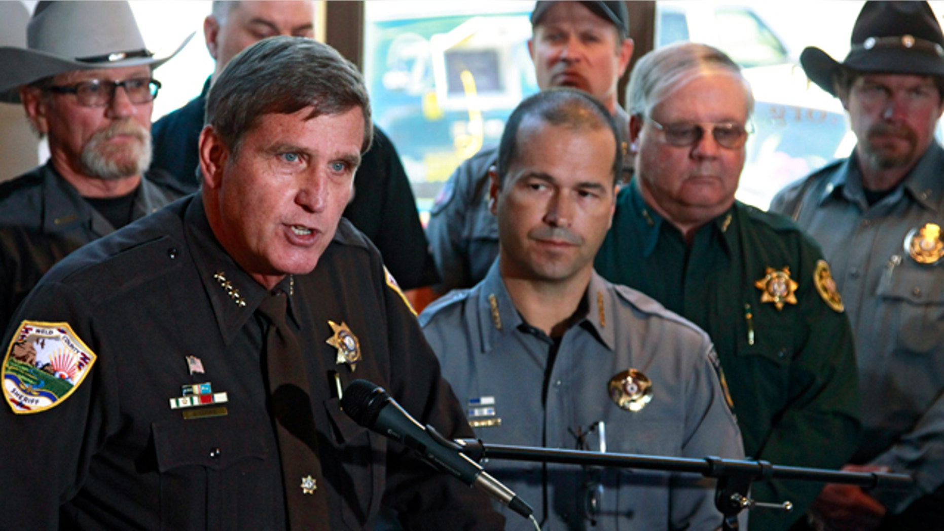 May 17 2013: Weld County, Colo., Sheriff John Cooke, left, with El Paso County Sheriff Terry Maketa, center right, and other sheriffs standing behind him, speaks during a news conference at which he announced that 54 Colorado sheriffs are filing a federal civil lawsuit against two gun control bills passed by the Colorado Legislature, in Denver.