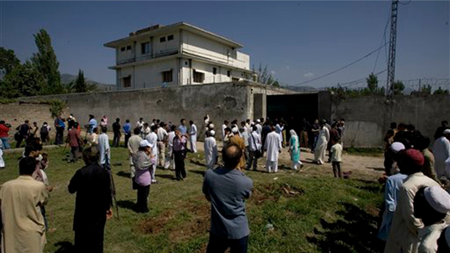 Local people and media gather outside the perimeter of the compound where Usama bin Laden was caught and killed in Abbottabad, Pakistan, May 3.