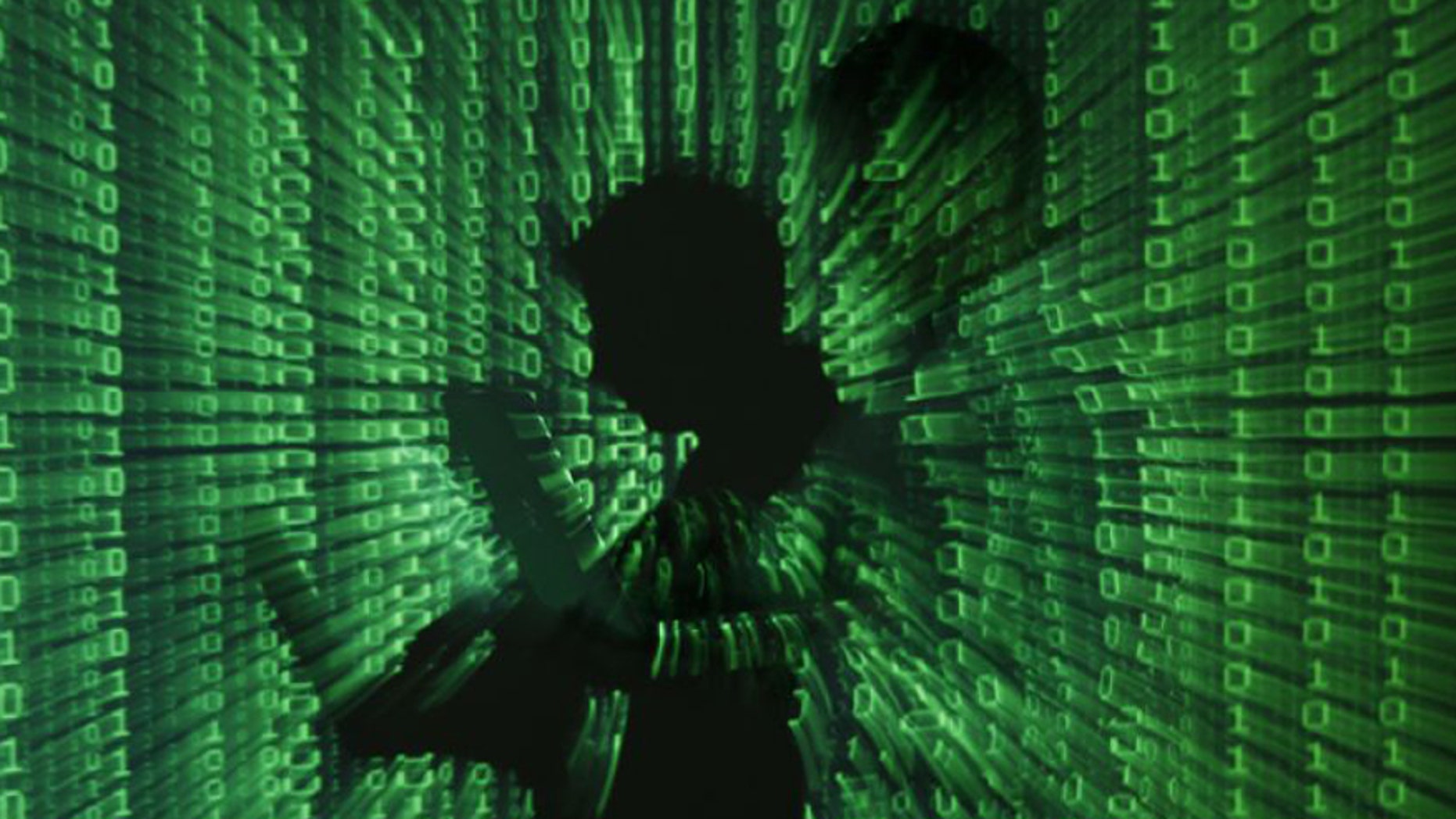 Photo illustration shows projection of binary code on a man holding a laptop computer. (Reuters)