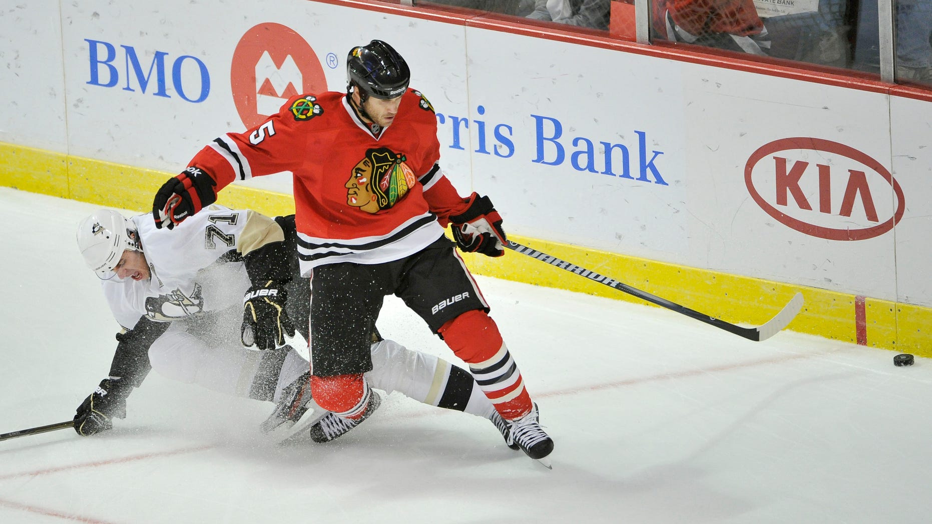 FILE - In this Sept. 30, 2011 file photo, Chicago Blackhawks defenseman Steve Montador, right, and Pittsburgh Penguins center Evgeni Malkin, of Russia, go for the puck during the first period of a preseason NHL hockey game, in Chicago. Montador is among a group of plaintiffs in a lawsuit brought against the NHL over concussion repercussions that has grown to well over 100 former players, who believe the league ignored a duty to warn them of the risks of head injuries. (AP Photo/Brian Kersey, File)