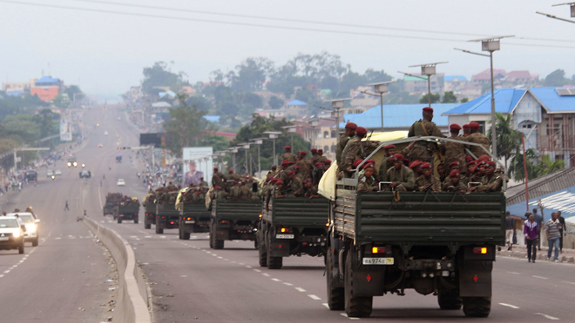Congo military trucks carrying Congolese troops drive in a main street after violence erupted due to the delay of the presidential elections in Kinshasa, Democratic Republic of Congo, Tuesday, Sept. 20, 2016.