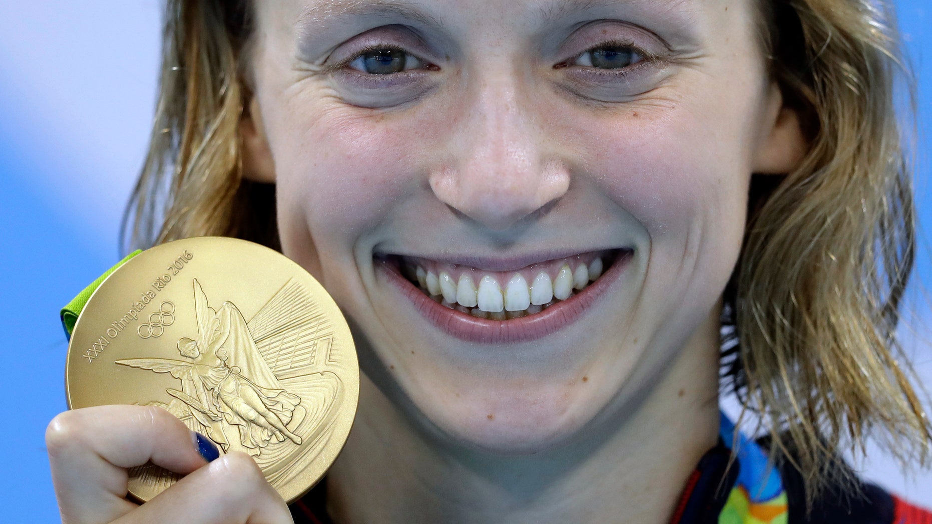 Aug. 12, 2016: United States' Katie Ledecky shows off her gold medal in the women's 800-meter freestyle medals ceremony during the swimming competitions at the 2016 Summer Olympics in Rio de Janeiro, Brazil.