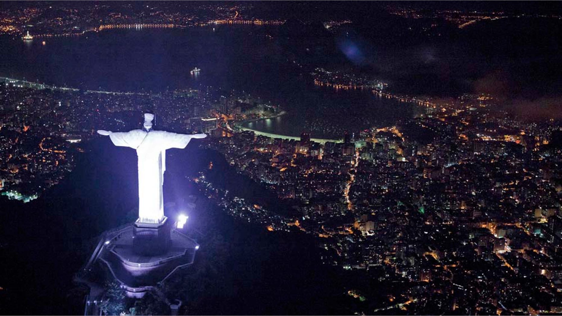 An aerial view of the iconic Christ the Redeemer statue before the lights that illuminate the statue are switched off to observe an hour of voluntary darkness for the global "Earth Hour" campaign, in Rio de Janeiro, Brazil, Saturday March 26, 2011. An estimated 1,000 landmarks' lights were turned off worldwide for 60 minutes at 8:30 p.m. local time, as a symbolic act to raise awareness about climate change and to make people aware of everyday energy use. (AP Photo/Felipe Dana)