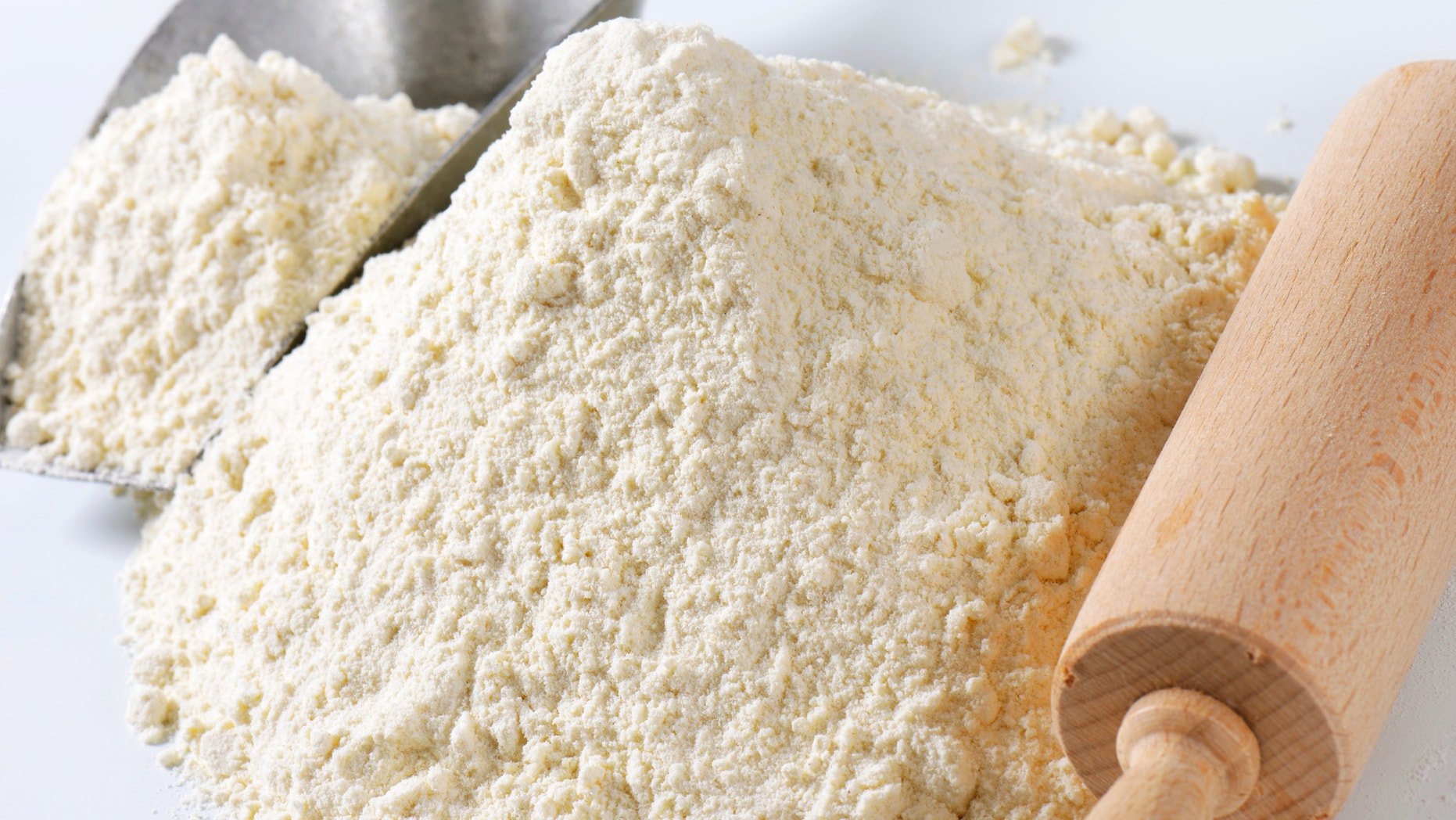 Pile of finely ground flour, wood rolling pin and metal scoop