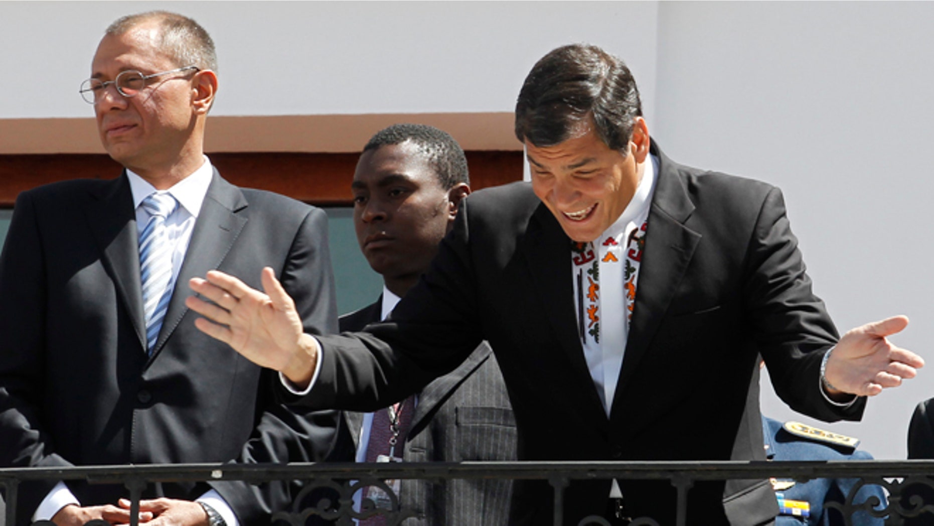 June 24, 2013: Ecuador President Rafael Correa, right, greets passersby from the balcony of the presidential palace.