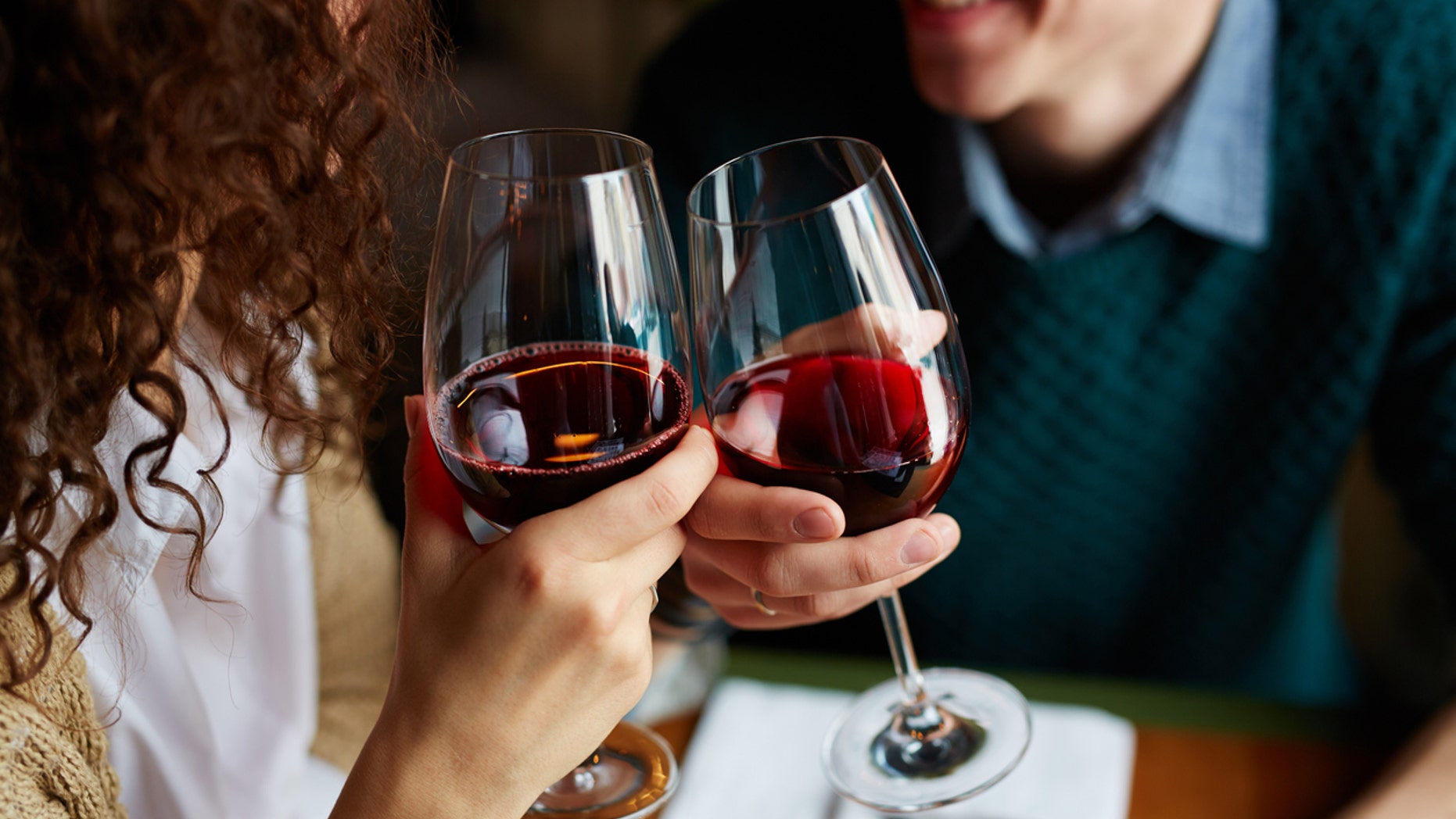 Amorous couple toasting with red wine in restaurant