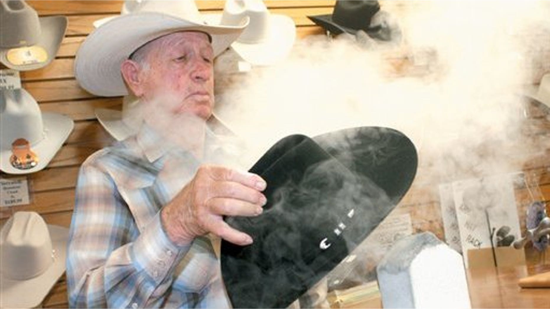 July 30: Johnny Grisak steams the inside of a cowboy hat at Dollar Boots & Jeans in Alamogordo, N.M. Grisak, an 80-year-old Alamogordo native who grew up on a ranch, learned how to crease hats the old-school way, from his cowboy father and grandfather, who lived in New Mexico long before it was ever granted statehood. (AP)