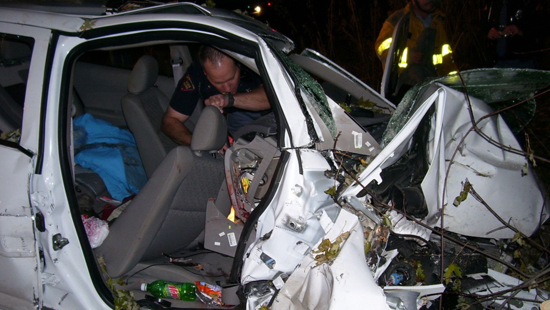 In this Oct. 24, 2006 photo provided by the St. Croix County Sheriff's Office, police investigate the wreckage of a 2005 Chevrolet Cobalt that crashed in St. Croix County, killing Natasha Weigel, 18, and Amy Lynn Rademaker, 15, and injuring the 17-year-old driver, Megan Ungar-Kerns. The vehicle's ignition was found in the accessory position and the air bags didnt deploy. General Motors recent recall of 2.6 million small cars, including the 2005 Cobalt, has shed light on an unsettling fact: Air bags might not always deploy when drivers _ and federal regulators _ expect them to. (AP Photo/St. Croix County Sheriff's Office)