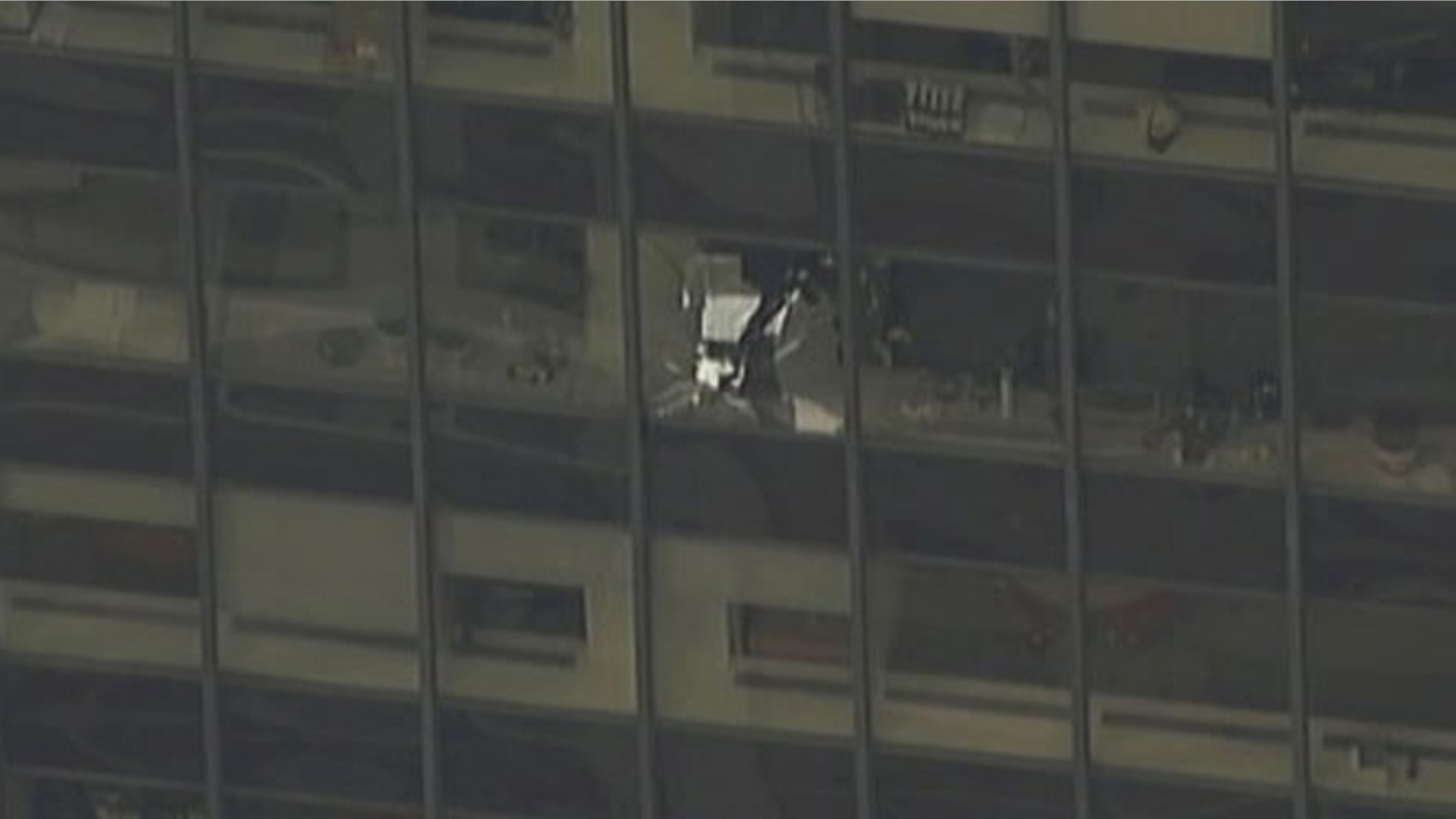 A news helicopter showed a shattered window on the NYC office building with firefighters investigating.