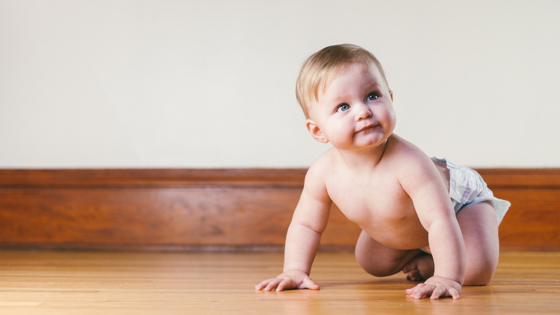 Crawling baby on the wooden floor