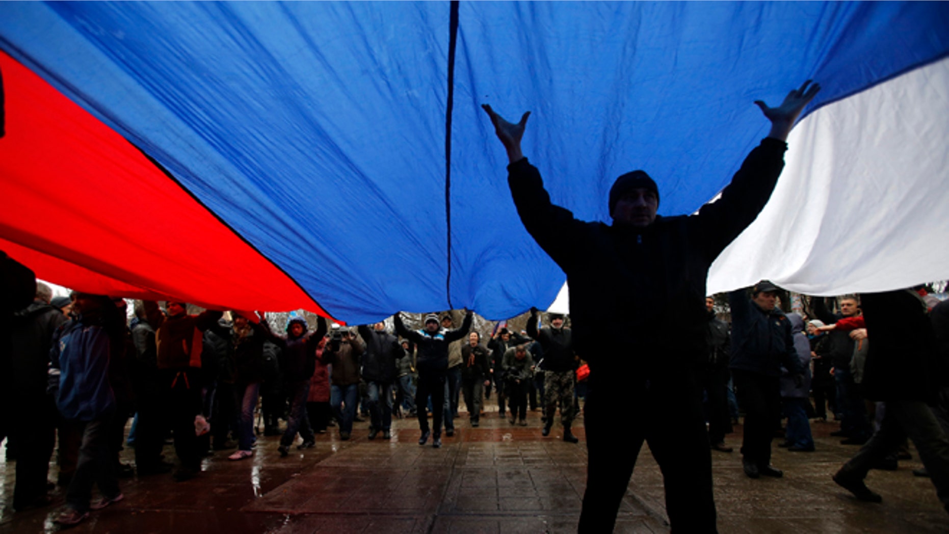 Feb. 27, 2014: Pro-Russian demonstrators march with a huge Russian flag during a protest in front of a local government building in Simferopol, Crimea, Ukraine.