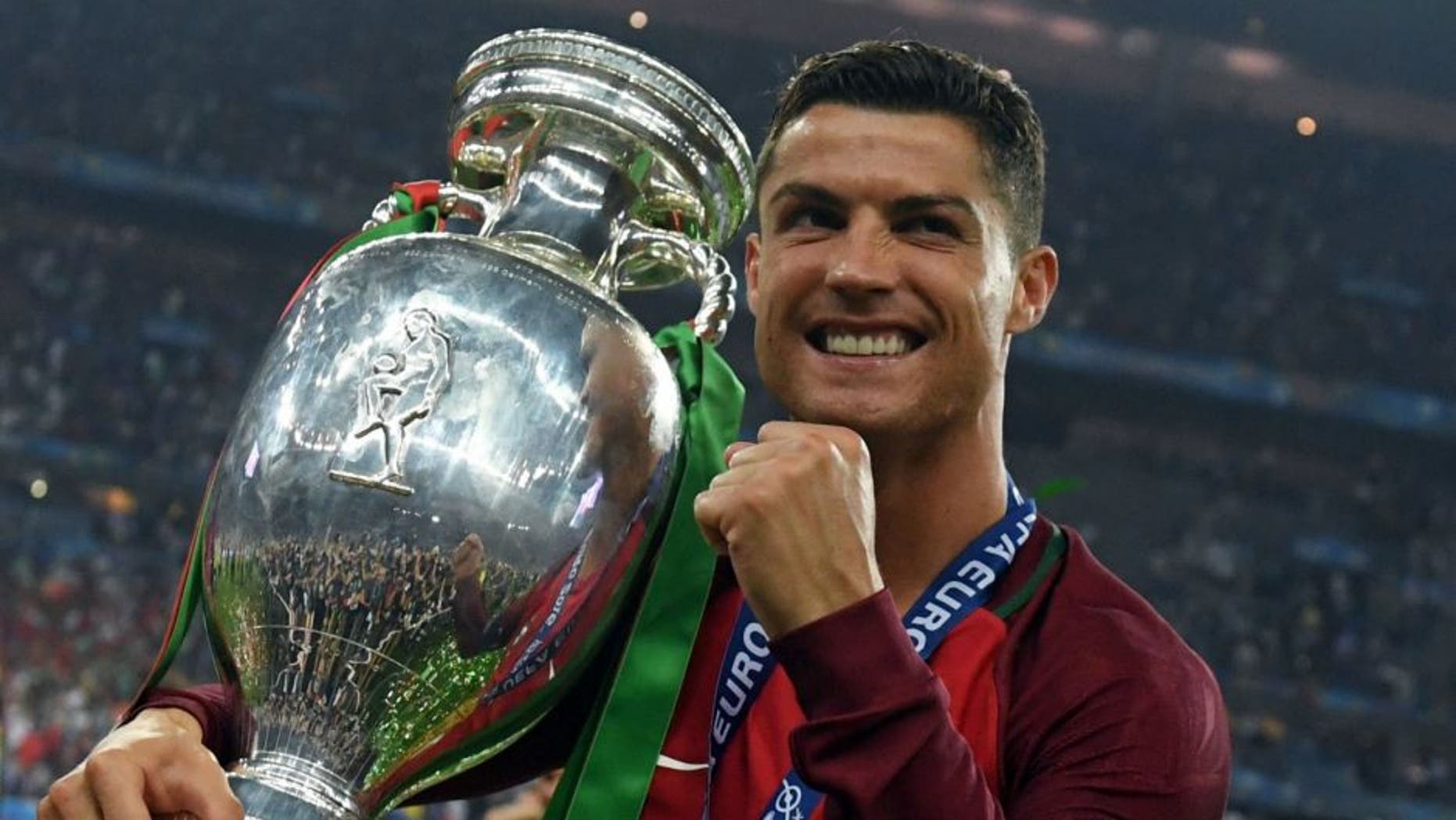 Portugal's forward Cristiano Ronaldo smiles while posing with the trophy after Portugal won the Euro 2016 final football match between Portugal and France at the Stade de France in Saint-Denis, north of Paris, on July 10, 2016. / AFP / FRANCISCO LEONG (Photo credit should read FRANCISCO LEONG/AFP/Getty Images)