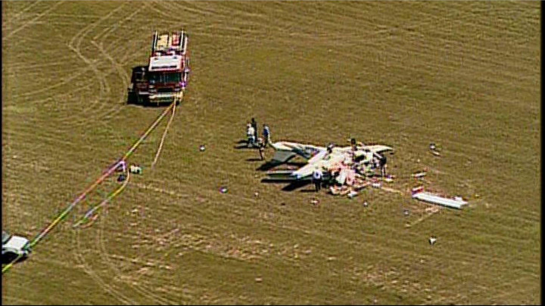 Emergency crews survey wreckage after two planes collide in midair near a west Georgia airport.