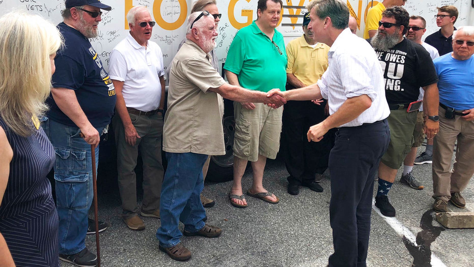 In this Thursday, July 26, 2018 photo, Westport tech entrepreneur and Navy veteran Steve Obsitnik, right, one of five Republicans running for governor, meets with voters in Waterford, Conn., during a campaign event ahead of the Aug. 14 primary. Obsitnik, who was stationed at the U.S. Naval Submarine Base in Groton, said he's been campaigning for a while in eastern Connecticut, where many communities voted for Donald Trump. (AP Photo/Susan Haigh)
