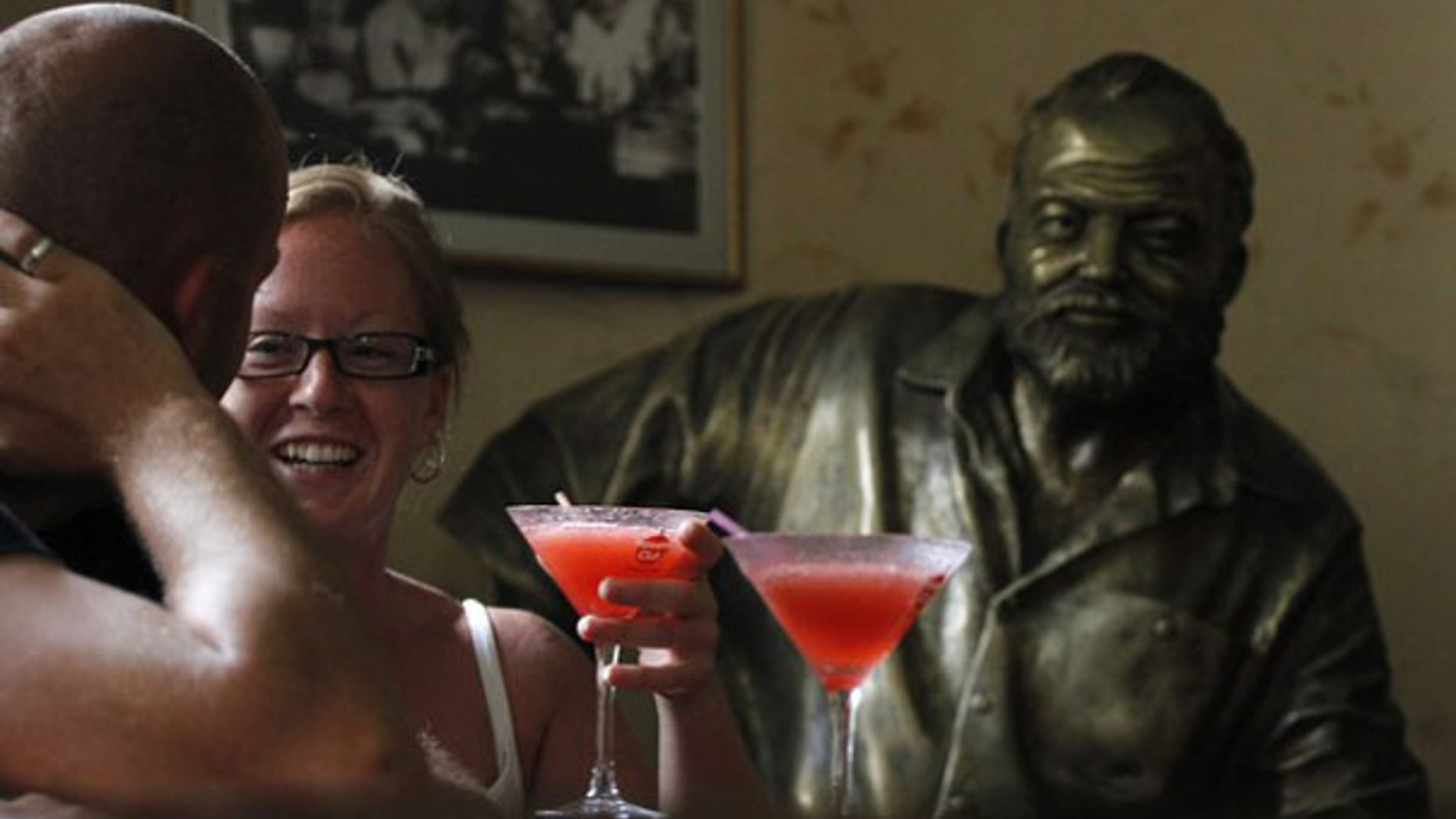 Tourists sit in front of their Daiquiris beside a life-size bronze statue of U.S. writer Ernest Hemingway at his regular spot at The Floridita bar in Havana. The Noble-prize winning writer spent considerable time in Cuba between 1940 and his death in 1961. REUTERS