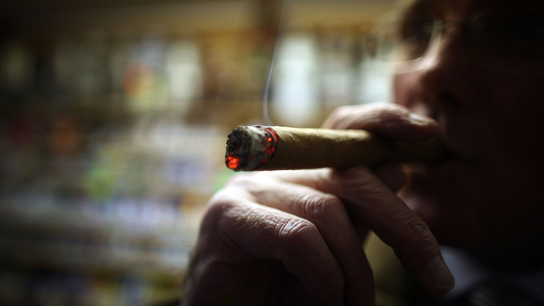 LIVERPOOL, UNITED KINGDOM - DECEMBER 09: Cigar lover Paul Clarke samples a Havana cigar in Turmeau's, Liverpool's last remaining tobacconist shop on December 9, 2008, in Liverpool, England. The UK government today announced plans to ban the display of cigarettes and tobacco for sale in shops. Many licensed tobacconists are wondering how the legislation will effect them and are hoping for some sort of exclusion, such as the one in existence where customers are allowed to sample and smoke tobacco inside. (Photo by Christopher Furlong/Getty Images)