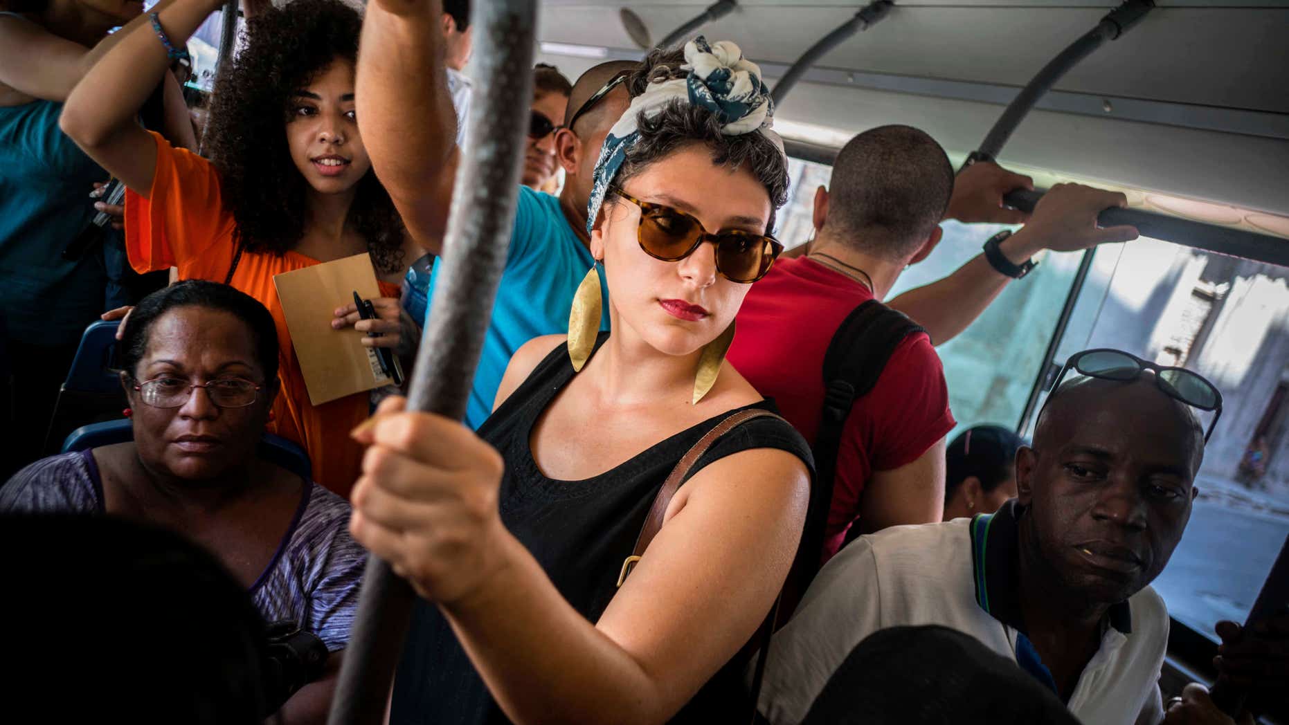 En esta foto del 12 de junio de 2016, la cubanoestadounidense Fontaine Capel, centro, viaja en autobús en La Habana, Cuba. Capel viajó a Cuba con CubaOne, un programa inspirado en el restablecimiento de las relaciones entre Estados Unidos y Cuba. (AP Foto/Ramon Espinosa)