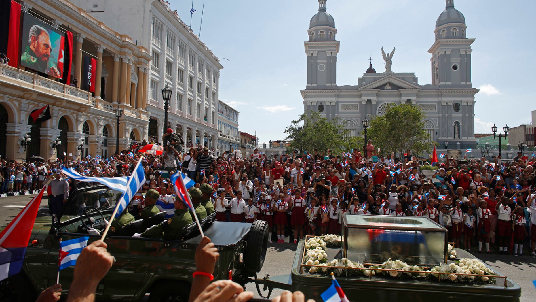 People chant "I am Fidel!" as the motorcade carrying the ashes of the late Cuban leader Fidel Castro leaves Cespedes park in Santiago, Cuba, Saturday, Dec. 3, 2016.