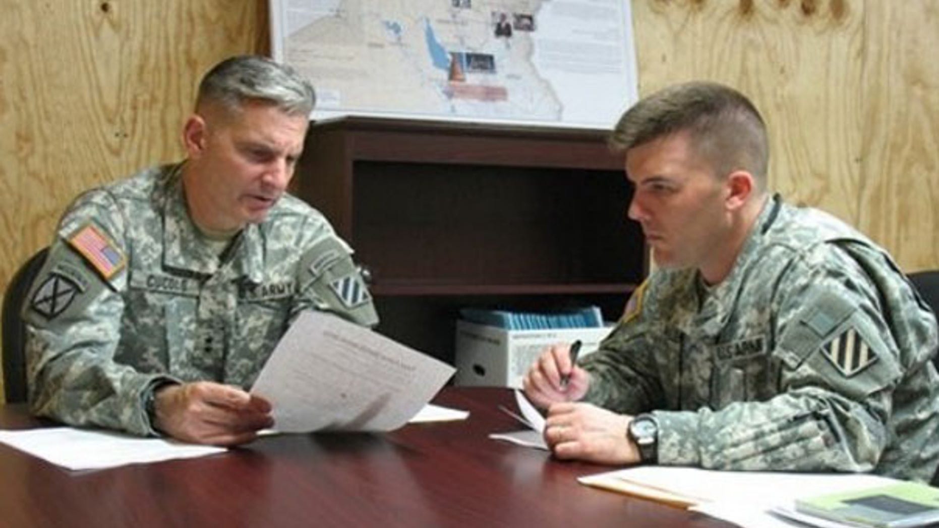 In this June 23 file photo, Maj. Gen. Anthony Cucolo, left, prepares for a mock television interview with his public affairs officer, Maj. Jeff Allen, at Fort Stewart, Ga. (AP Photo)
