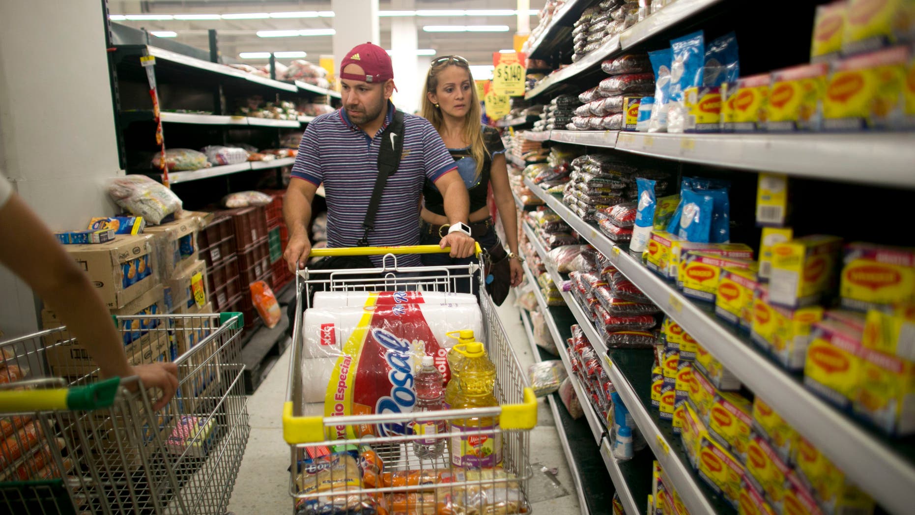 Ramiro and Tebie Gonzalez Ramirez shop for food in Cucuta, Colombia, Sunday, July 17, 2016.