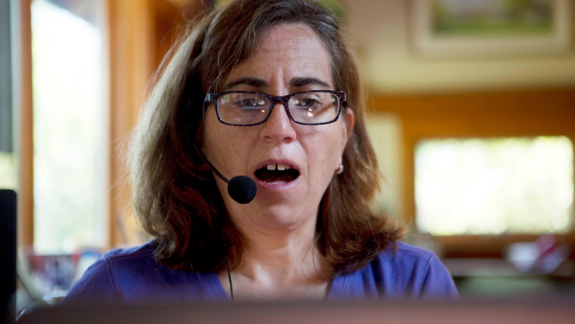 In this Friday, June 24, 2016, photo , Jessie Levine records phrases on her computer in Springfield, N.H. Levine was diagnosed with Lou Gehrig's disease or ALS in 2015 and it has caused her speech to become slow and slurred. She is now exploring a new way to restore her voice via speech synthesis, or the artificial production of human speech. (AP Photo/Jim Cole)
