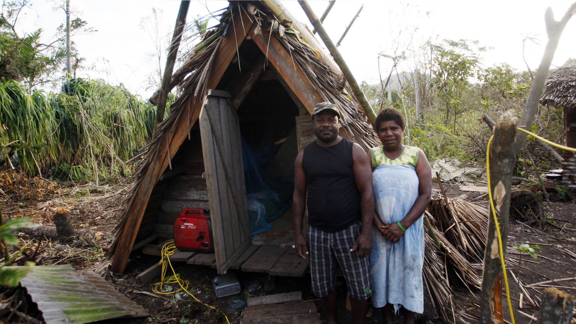 March 19, 2015: Kelson Hosea and wife Joyce Hosea stand next to the hut Kelson built to withstand Cyclone Pam.
