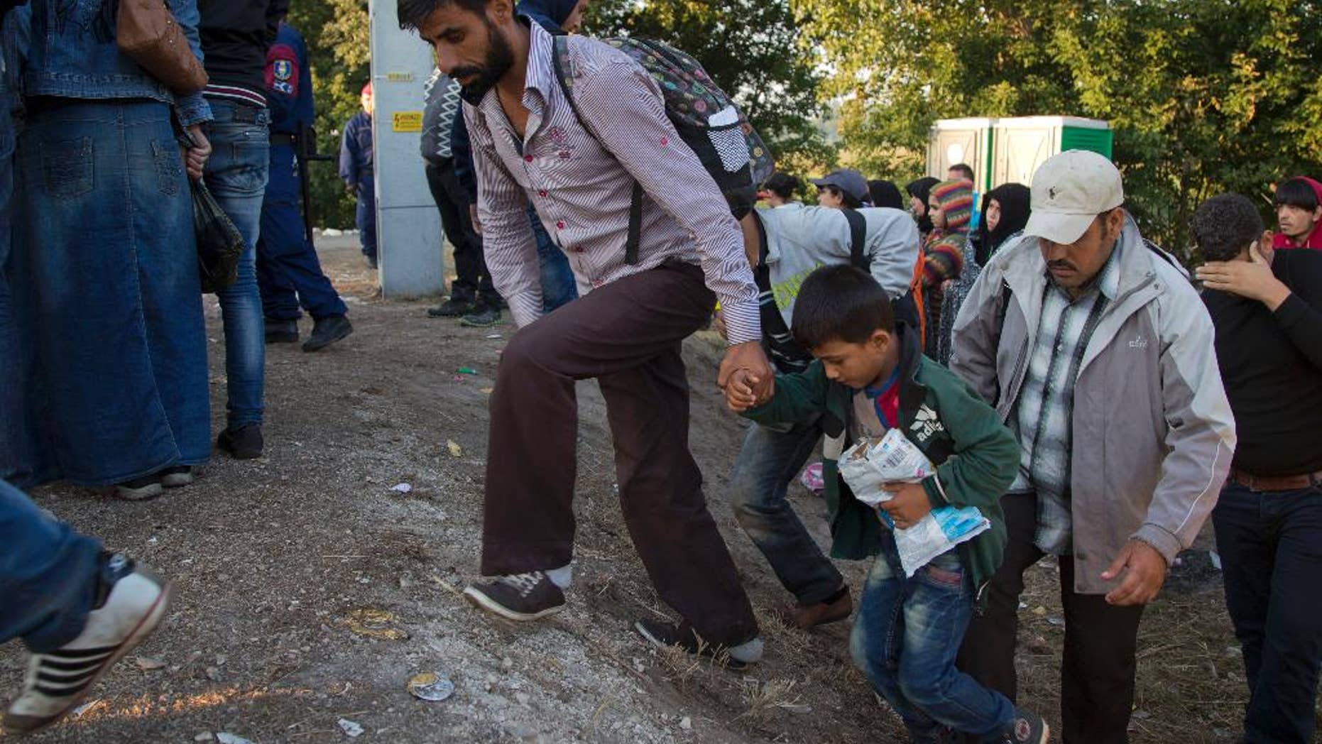 Aug. 31, 2015: Refugees who crossed the border from Serbia climb on a road to board a bus to transfer them to a refugee camp, in Asotthalom, Hungary. Migrants fearful of death at sea in overcrowded and flimsy boats have increasingly turned to using a land route to Europe through the Western Balkans.
