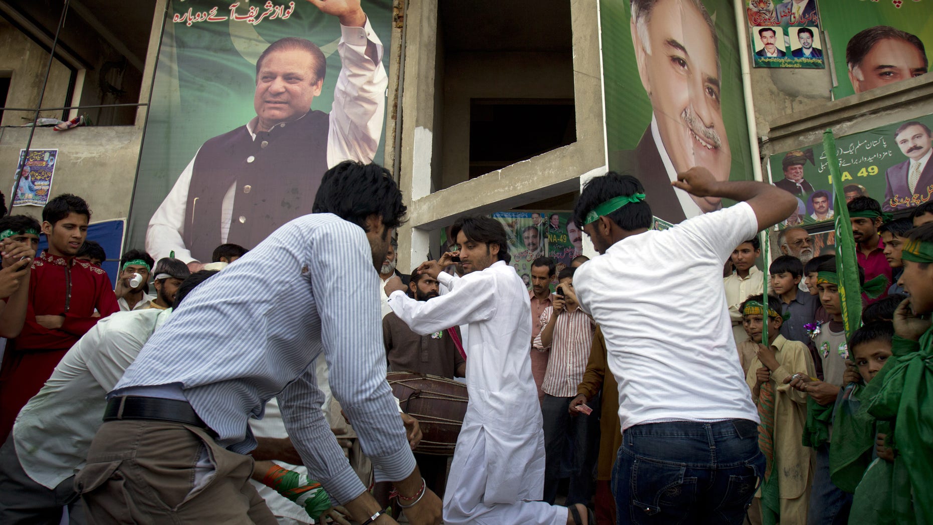 Supporters of Pakistan's former Prime Minister Nawaz Sharif celebrate the victory of their leader in Islamabad, Pakistan on Sunday, May 12, 2013. Sharif looked set Sunday to return to power for a third term, with an overwhelming election tally that just weeks ago seemed out of reach for a man who had been ousted by a coup and was exiled abroad before clawing his way back as an opposition leader. (AP Photo/B.K. Bangash)
