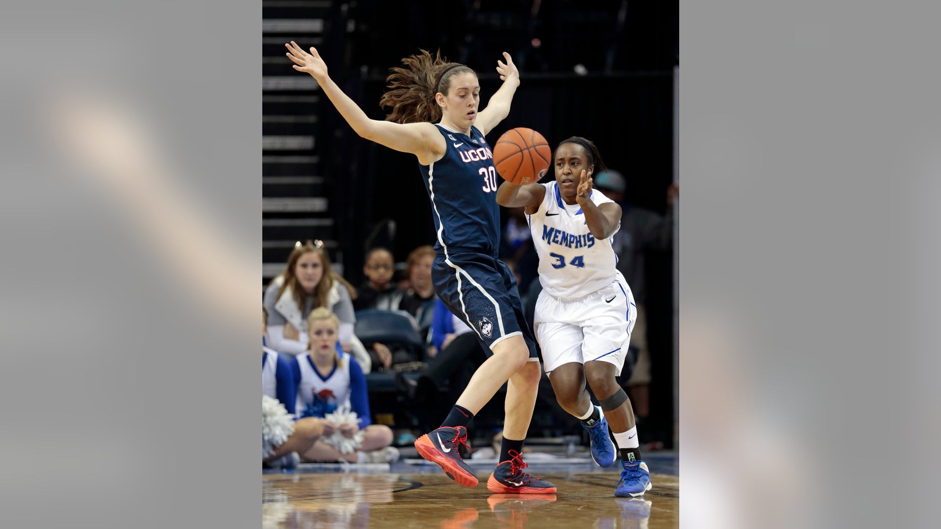 Memphis guard Devin Mack (34) passes around Connecticut forward Breanna Stewart (30) in the second half of an NCAA college basketball game Saturday, Jan. 4, 2014, in Memphis, Tenn. (AP Photo/Mark Humphrey)