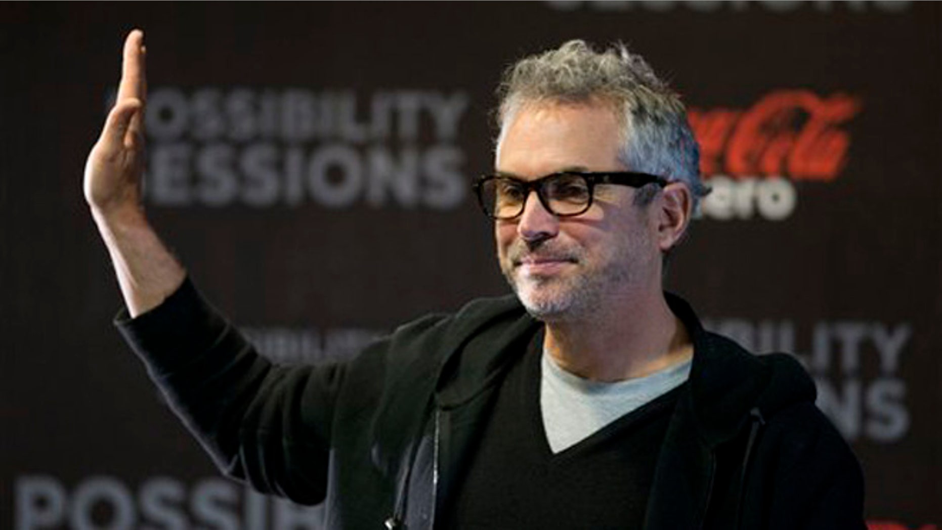 Alfonso Cuaron waves at the close of a press conference in Mexico City, Wednesday, April 30, 2014.