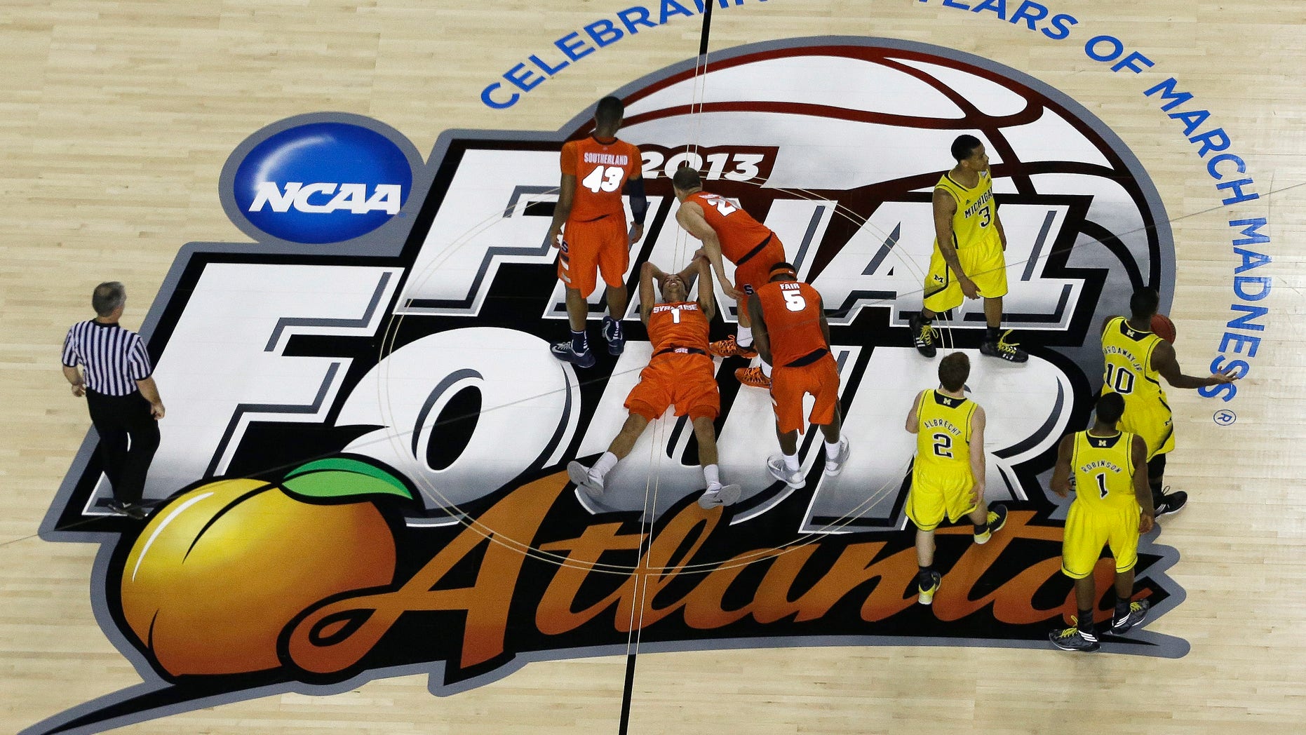 Syracuse's Michael Carter-Williams (1) lies on the court as Syracuse's Brandon Triche (20) helps him during the second half of the NCAA Final Four tournament college basketball semifinal game against Michigan, Saturday, April 6, 2013, in Atlanta. (AP Photo/David J. Phillip)