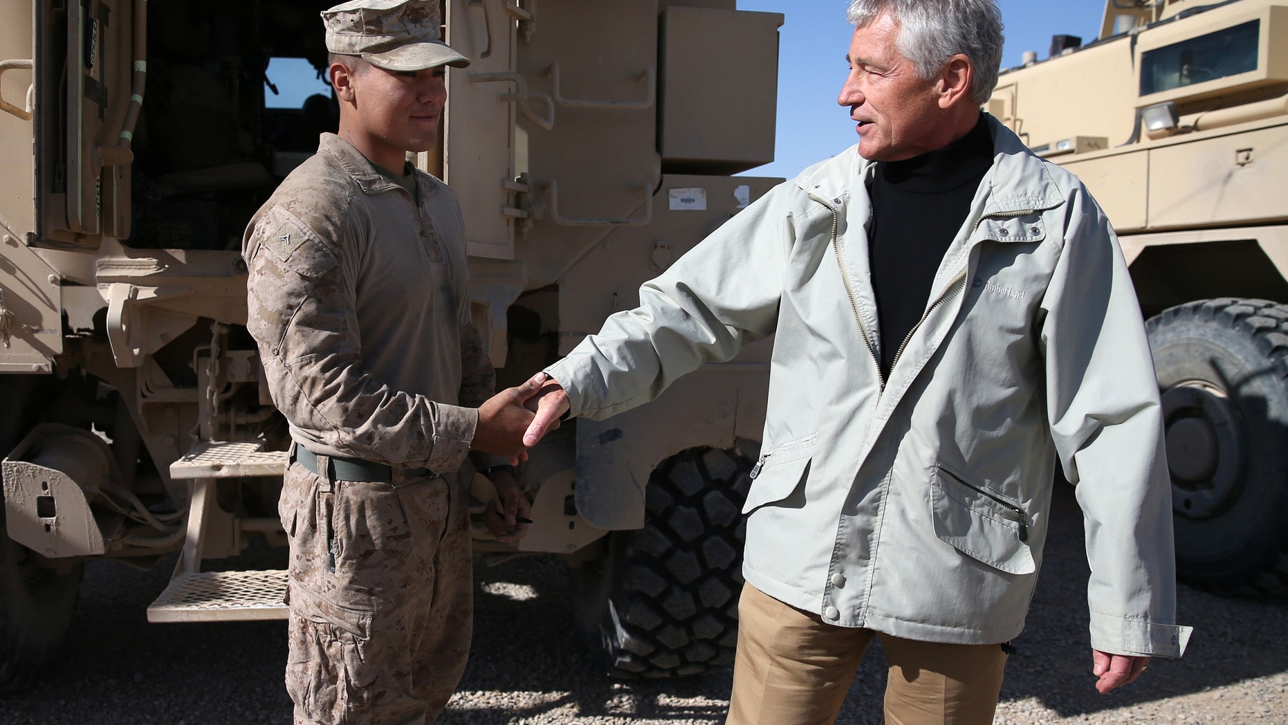 U.S. Secretary of Defense Chuck Hagel, right, shakes hands with U.S. Marine Lance CPL. Arron Corona as he works on a MRAP vehicle, at Camp Bastion, Afghanistan, Sunday, Dec. 8, 2013. Hagel spoke with troops and thanked them for being deployed for the holidays. (AP Photo/Mark Wilson, Pool)