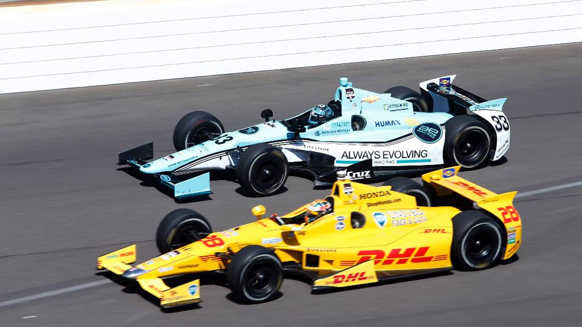 Ryan Hunter-Reay, bottom and James Davison, of Australia, head into the first turn on the final day of practice for the Indianapolis 500 IndyCar auto race at the Indianapolis Motor Speedway in Indianapolis, Friday, May 23, 2014. The 98th running of the Indianapolis 500 is Sunday. (AP Photo/Tom Strattman)