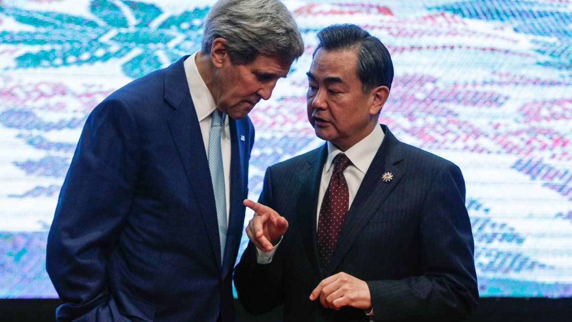 U.S. Secretary of State John Kerry, left, and Chinese Foreign Minister Wang Yi, chat after the group photo session before the East Asia Summit Foreign Ministers' Meeting in Kuala Lumpur, Malaysia on Thursday, Aug. 6, 2015. (AP Photo/Joshua Paul)