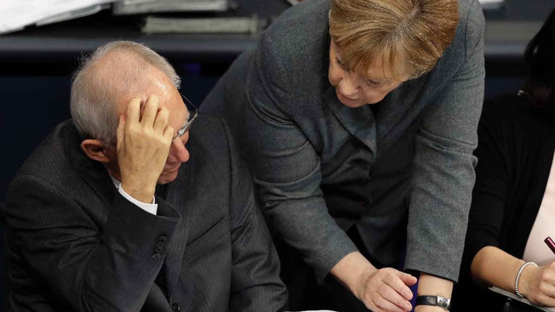 German Chancellor Angela Merkel, right, and German Finance Minister Wolfgang Schaeuble, left, talk during a budget debate as part of a meeting of the German Federal Parliament, Bundestag, at the Reichstag building in Berlin, Germany, Tuesday, Nov. 22, 2016. (AP Photo/Michael Sohn)
