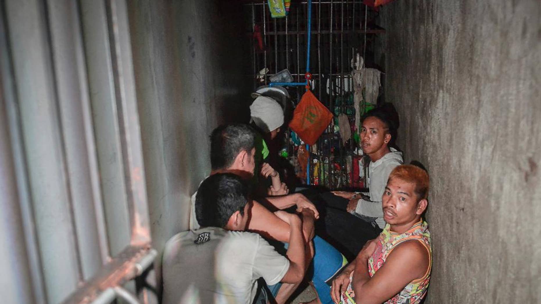 In this Thursday, April 27, 2017 photo, detainees crouch on the floor inside a secret jail after being discovered by the Commission on Human Rights at Police Station 1 at Tondo district in Manila, Philippines. Philippine police relieved a station chief and his staff on Friday after human rights representatives discovered the secret jail cell inside the Manila station where a dozen detainees complained they were being held for extortion. (AP Photo/Ezra Acayan)