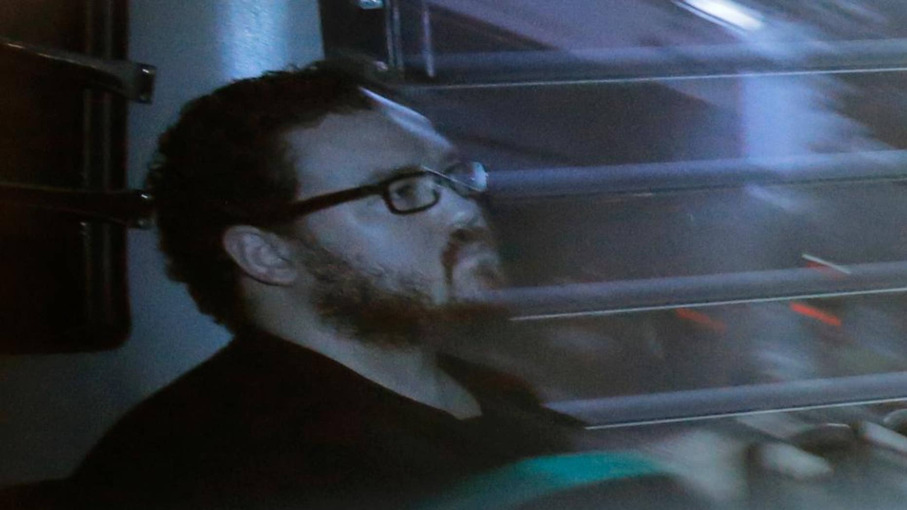 Rurik Jutting sitting in a prison bus in 2014.