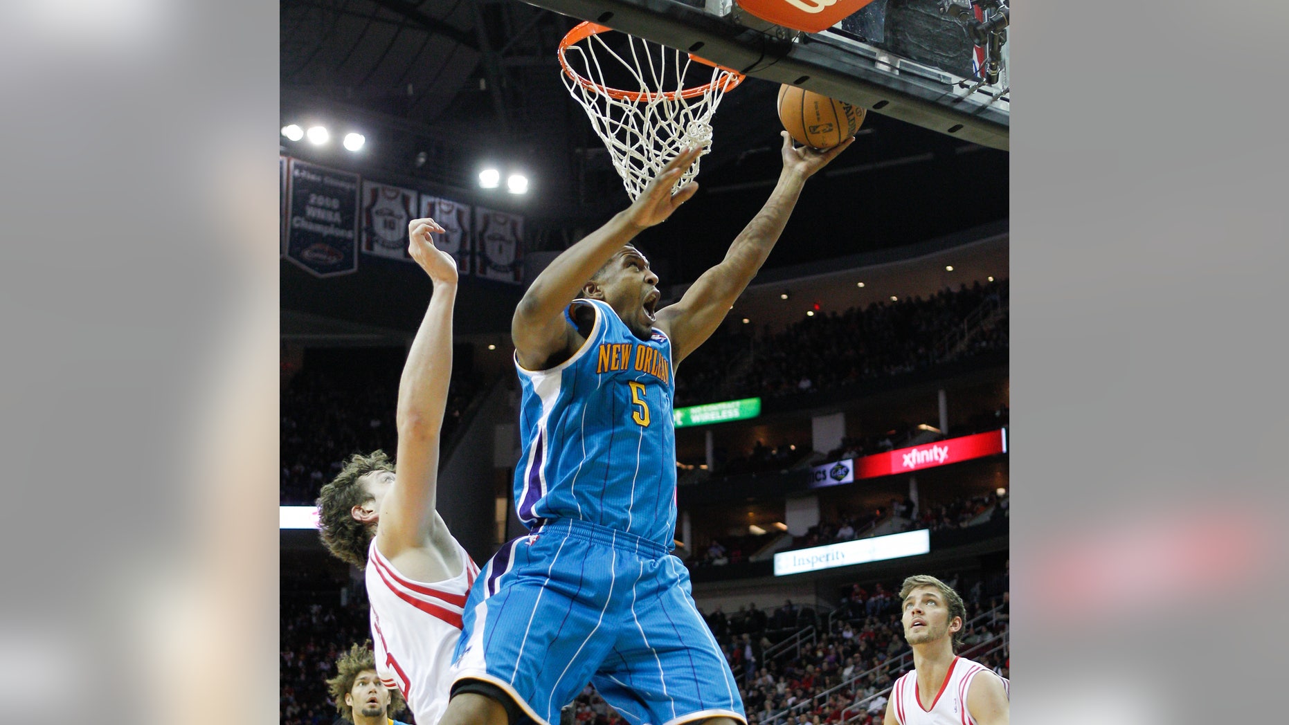 New Orleans Hornets small forward Dominic McGuire (5) drives to the basket for a layup past Houston Rockets center Omer Asik (3) during the first half of an NBA basketball game on Wednesday, Jan. 2, 2013, in Houston. (AP Photo/Bob Levey)