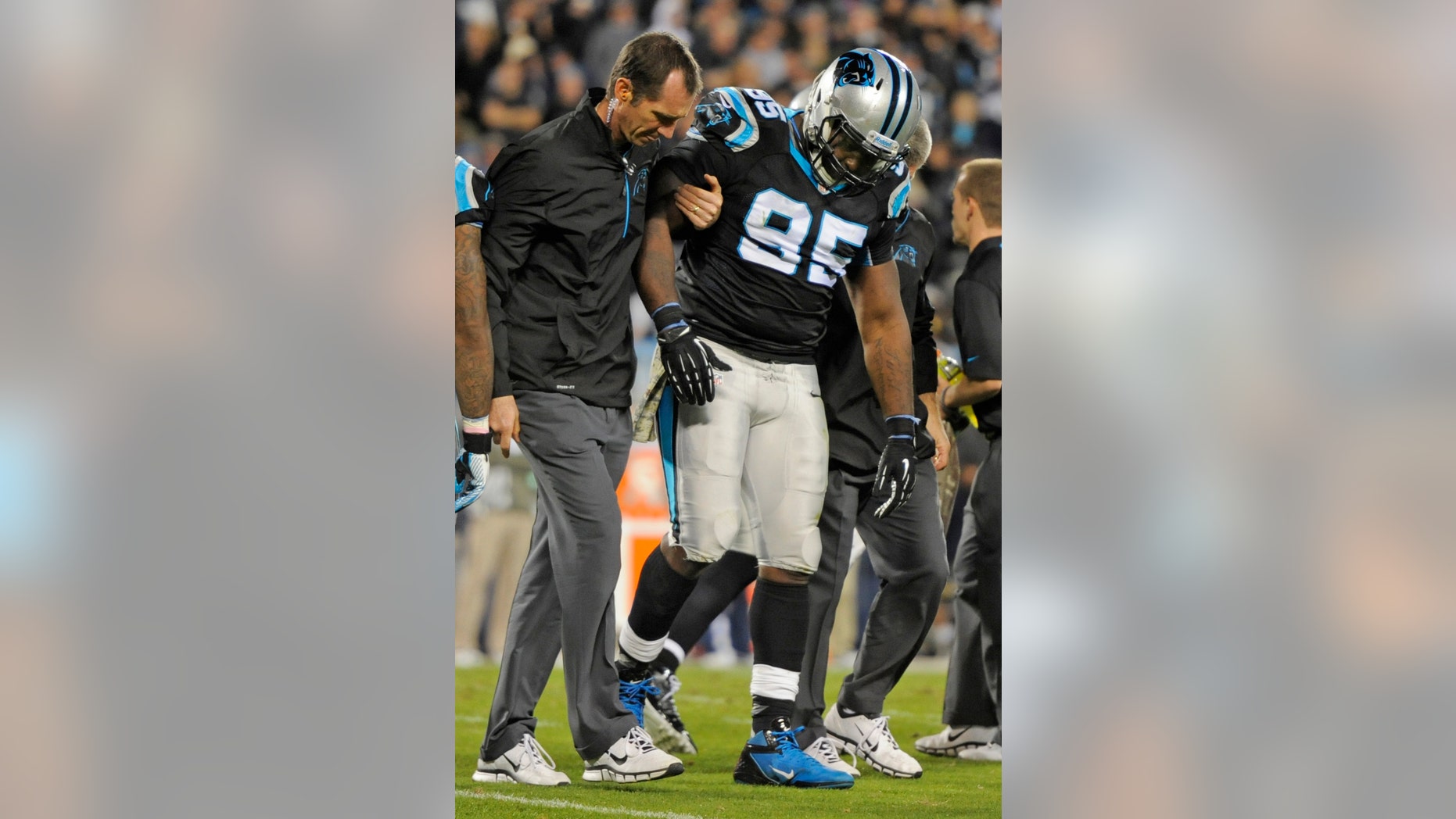 Carolina Panthers' Charles Johnson (95) is helped off the field after being injured against the New England Patriots during the second half of an NFL football game in Charlotte, N.C., Monday, Nov. 18, 2013. (AP Photo/Mike McCarn)