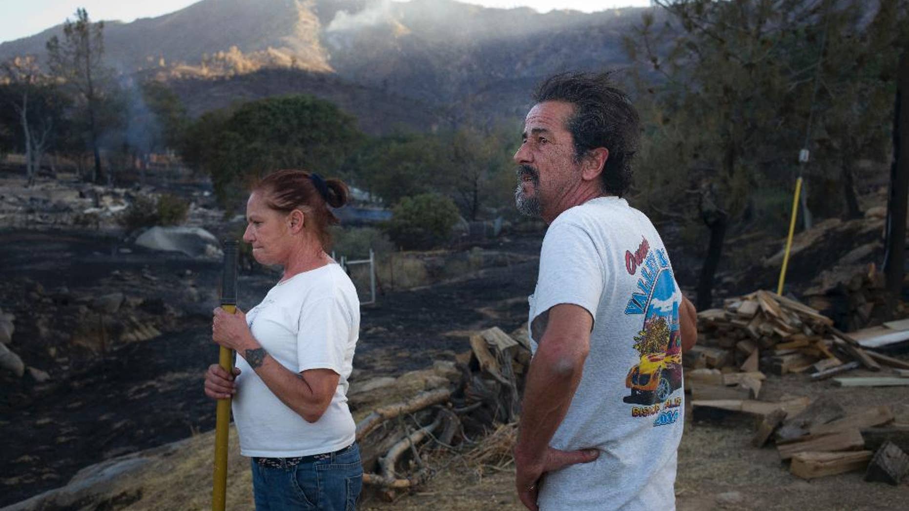 June 24, 2016: Rick Gutierrez, right, and wife, Jean, take a short break while putting out hotspots on their neighbor's property near Mountain Mesa, Calif.