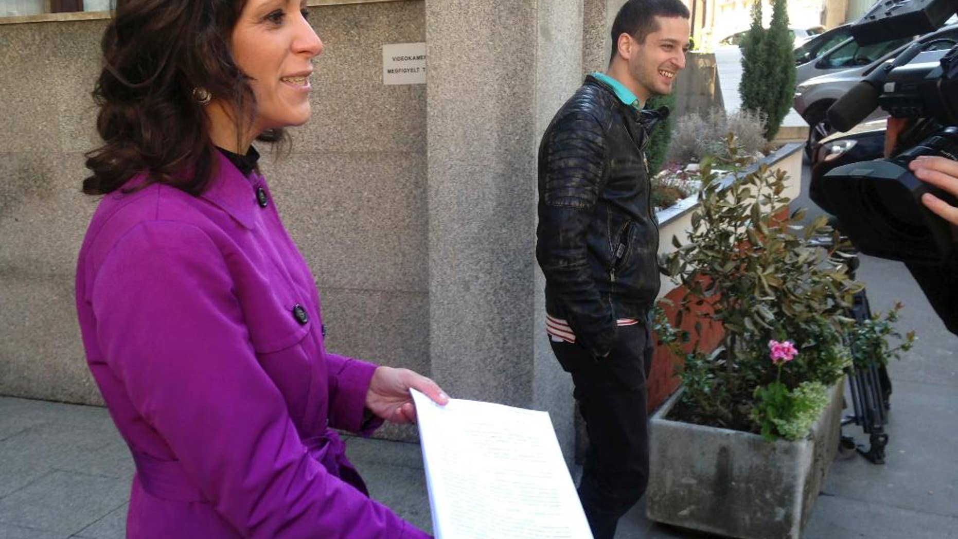Bernadett Szel, a lawmaker from the green party Politics Can Be Different, shows a copy of an appeal she presented to the Constitutional Court outside the court's headquarters on Friday, April 21, 2017. Szel and other opposition lawmakers are seeking the repeal of amendments to the law on higher education they say seeks to shut down Budapest-based Central European University, founded by billionaire philanthropist George Soros. (AP Photo/Pablo Gorondi)