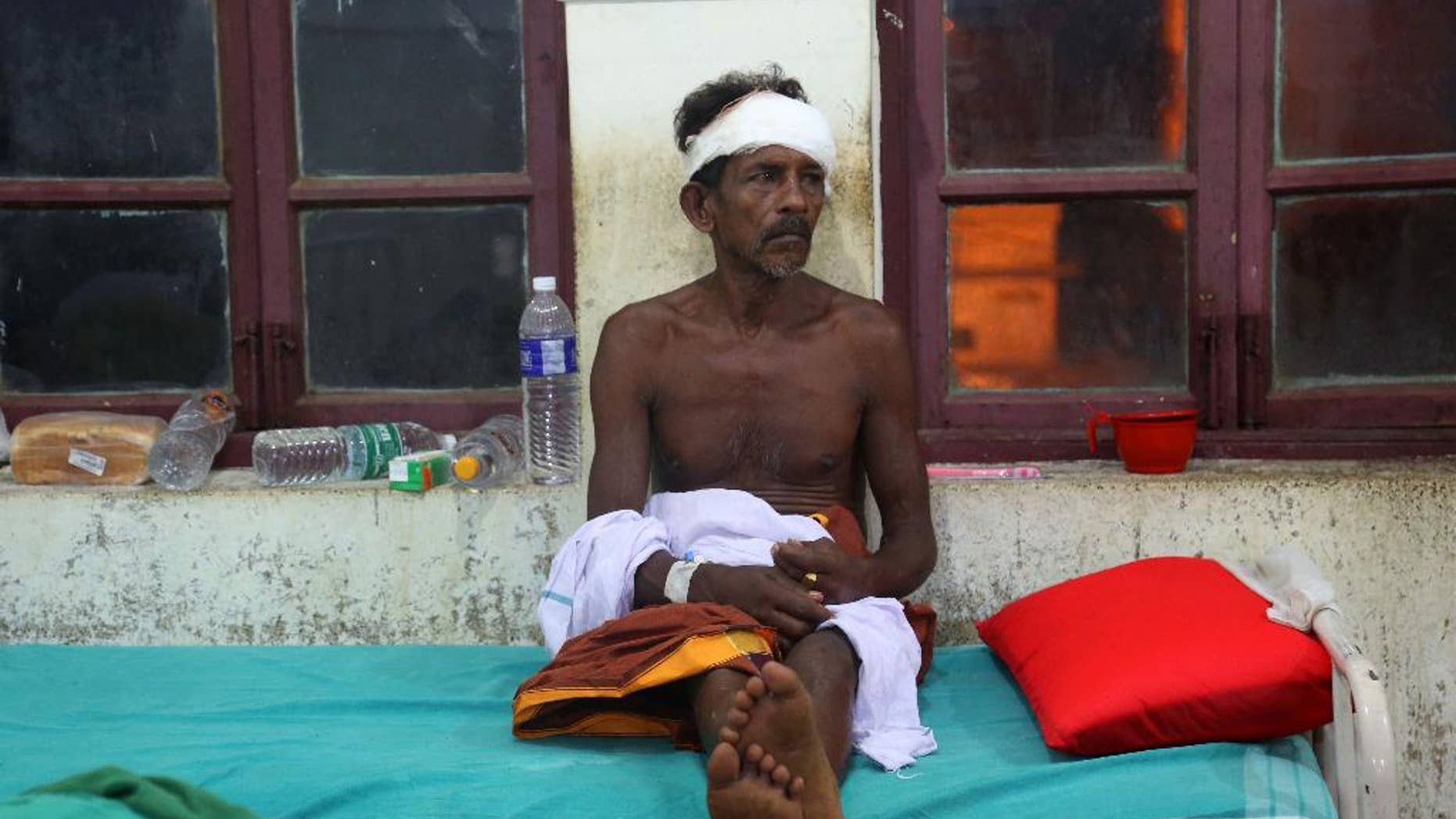 An injured man rests on a bed at the Kollam district hospital after a massive fire broke out during a fireworks display at the Puttingal temple complex in Paravoor village, Kollam district, southern Kerala state, India, Sunday, April 10, 2016. Dozens were killed and many more were injured when a spark from an unauthorized fireworks show ignited a separate batch of fireworks that were being stored at the temple complex, officials said. (AP Photo/Aijaz Rahi)