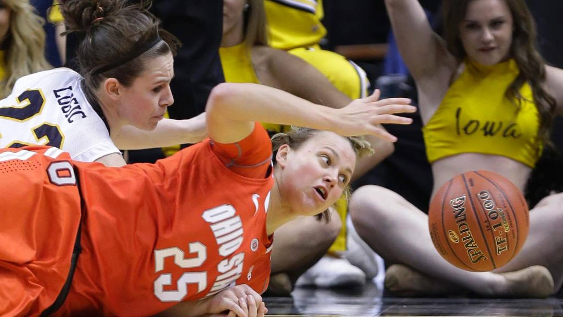 FILE - In this March 8, 2014 file photo, Ohio State guard Amy Scullion (25) and Iowa guard Samantha Logic go for a loose ball in the first half of an NCAA college basketball game in the semifinals of the Big Ten women's tournament in Indianapolis. Scullion had already graduated and been accepted into Ohio State’s medical school. A starter a year ago, she’s returning to a team that is short-handed because one player was kicked off the team and three others sustained season-ending knee injuries in the preseason. (AP Photo/Michael Conroy, File)