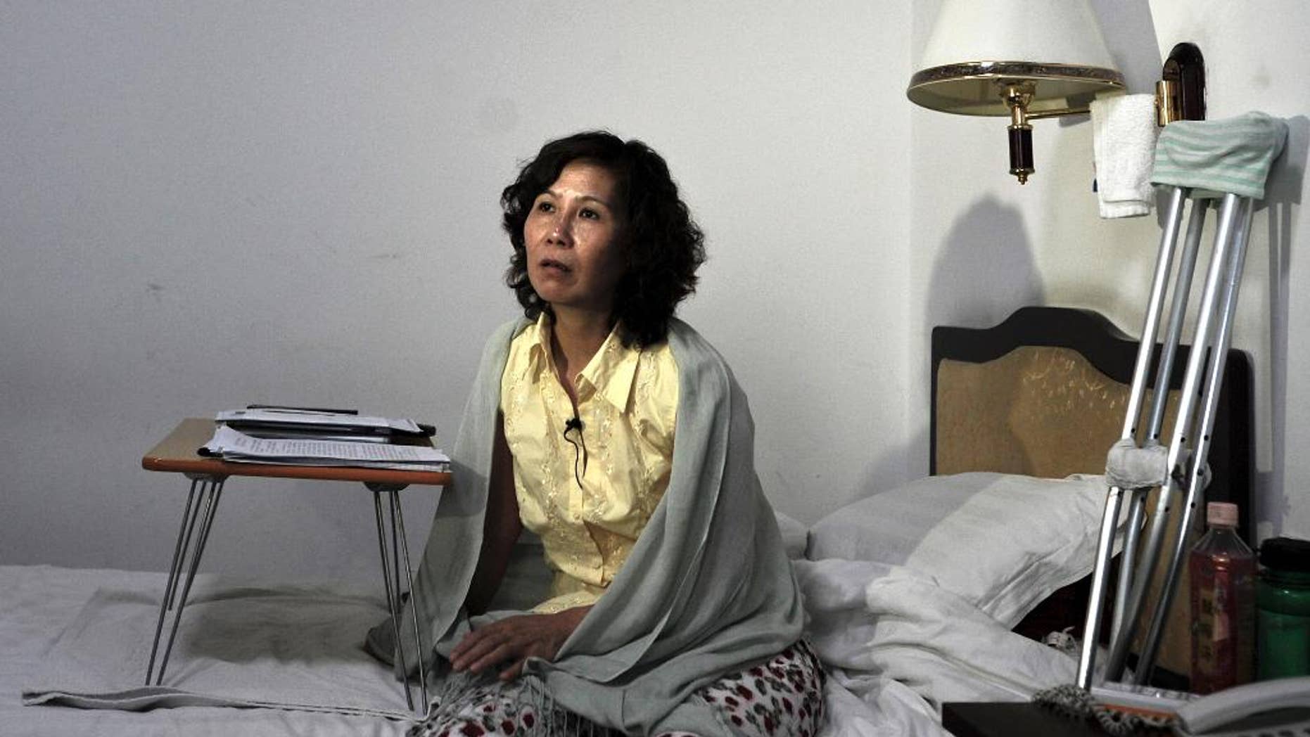 FILE - In this June 30, 2010, file photo, Chinese lawyer Ni Yulan sits on a bed in a hotel in Beijing. Ni was awarded the State Department's International Women of Courage Award for her work defending people forcibly evicted from their homes. Ni said that police stopped five Western diplomats who were trying to visit her in Beijing on Saturday, April 23, 2016, after she had been prevented from travelling to the United States to accept the award for her rights work. (AP Photo/Andy Wong, File)