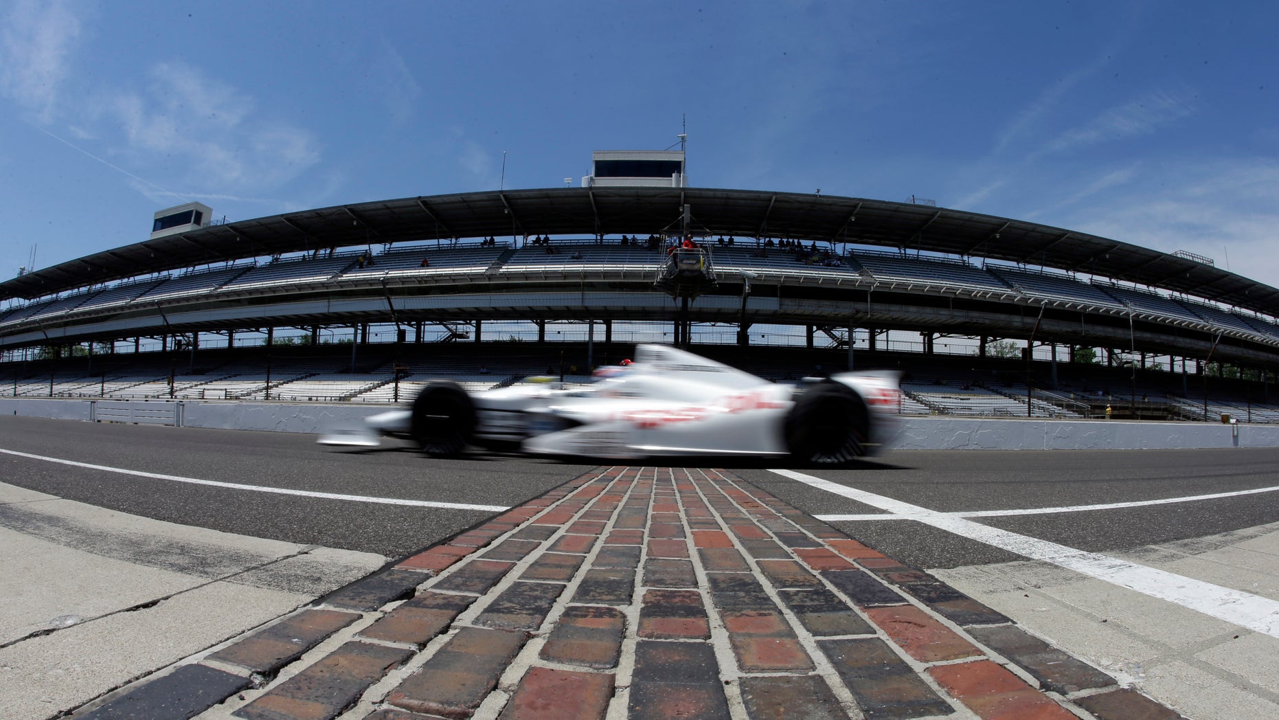 In this photo taken with a fisheye lens, Tristan Vautier, of France, drives across the start/finish line as he leaves the pit area during practice for the Indianapolis 500 auto race at the Indianapolis Motor Speedway in Indianapolis, Wednesday, May 15, 2013. (AP Photo/Darron Cummings)
