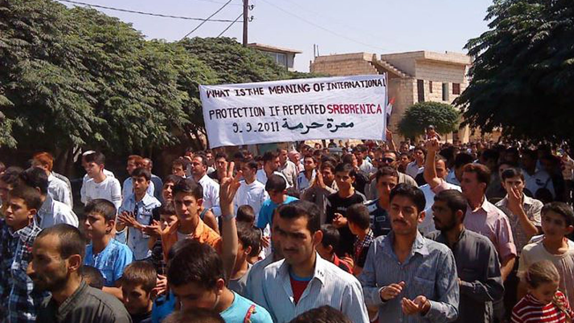 Anti-Syrian President Bashar Assad protesters march during a demonstration against the Syrian regime, at Maaret Harma village, in Edlib province, Syria, on Friday Sept. 9, 2011.