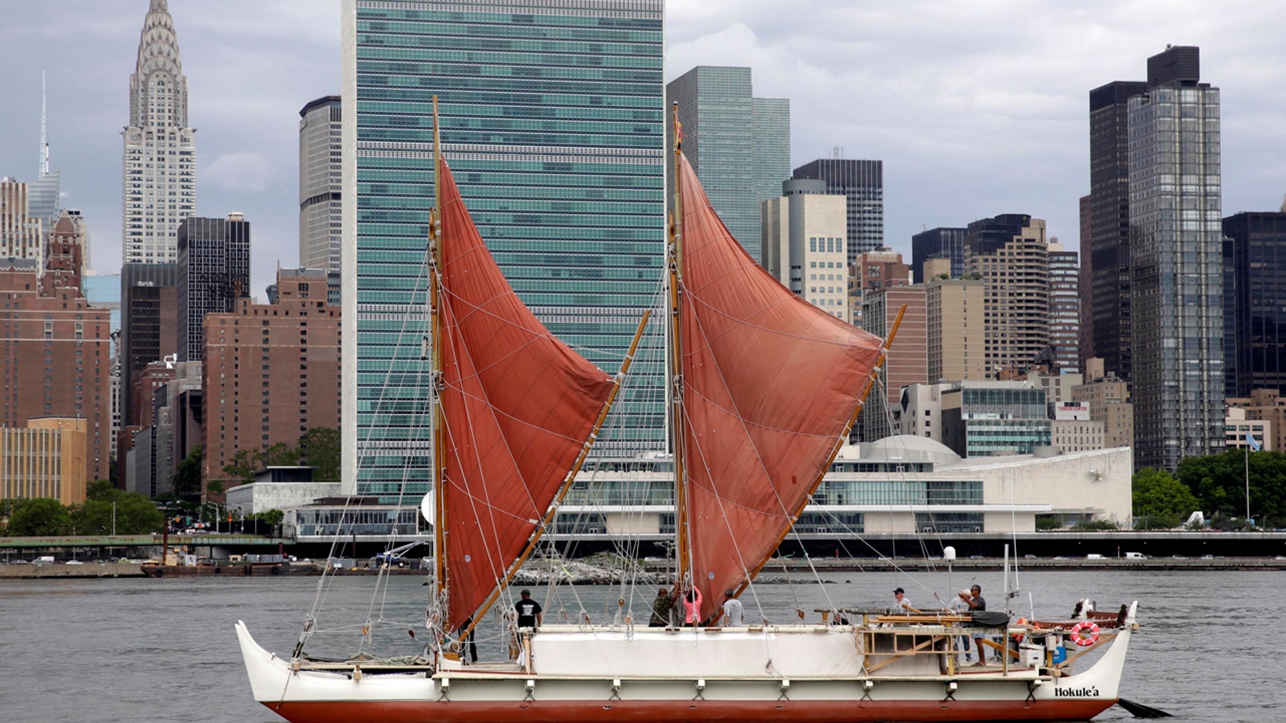 In this June 8, 2016, file photo, the traditional Polynesian voyaging canoe Hokulea, on an around-the-world journey, sails by the United Nations on New York's East River, during the World Oceans Day observance.
